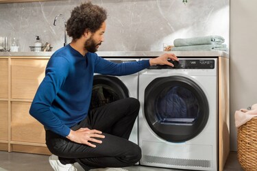A person selecting programme on a tumble dryer
