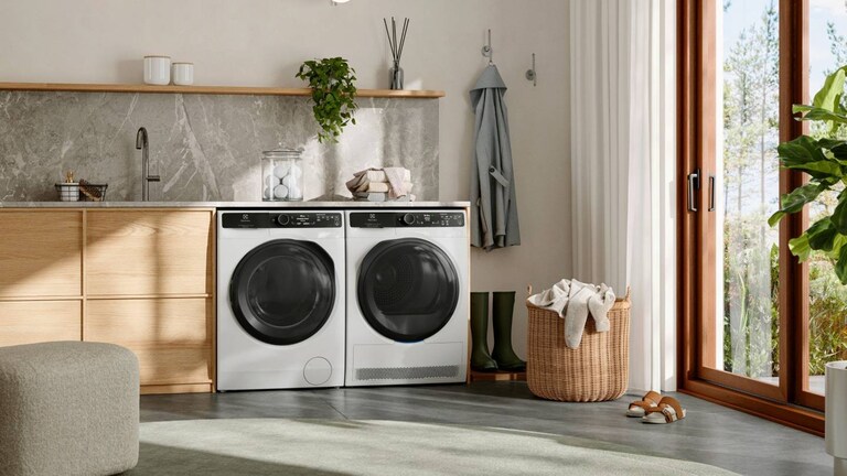 Laundry room with a washing machine and tumble dryer from Electrolux placed next to each other below a counter.