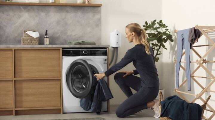 Woman loading an Electrolux washing machine 